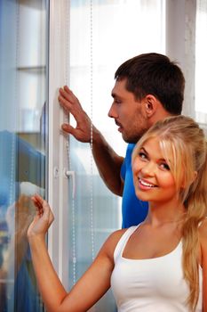 bright picture of happy couple at the window (focus on man)