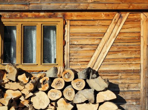 wood prepared for the fireplace near an old lodge up in the mountains