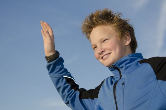 Happy kid with spiky hairstyle joyfully welcome against blue sky