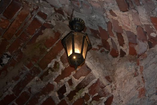 Old red bricks wall and light hanging on the wall. Dubno, Ukraine