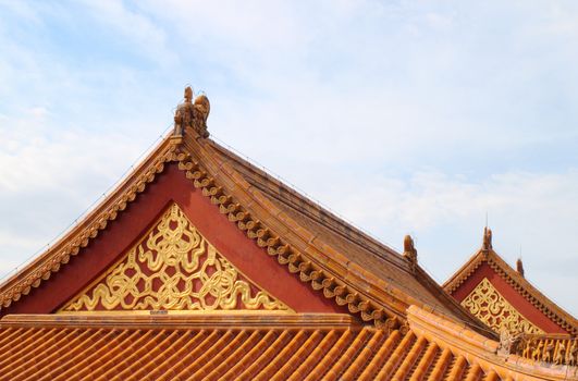 Detail on Chinese temple roof against blue sky.