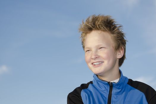 Portrait of happy teenager with spiky hairstyle against sky