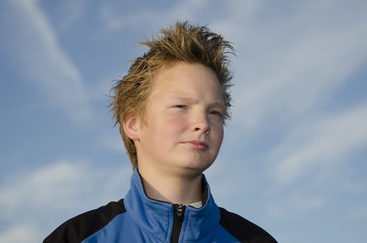Portrait of teenager with spiky hair against blue sky