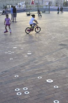 Barcelona, Spain - June 18, 2010 : children play at modern urban playground at the Moll d'Espanya in Port Vell area. Barcelona is not only historical sightseeing place but the leader in ultra-modern architecture and art.