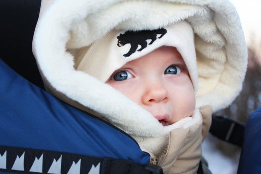 A close up image of a baby in a parka and a tuque