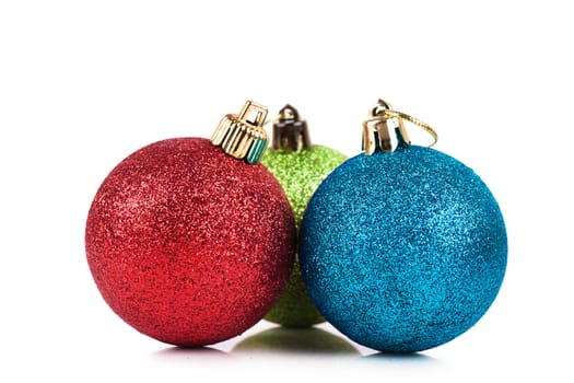 Red, blue and green christmas decorations over white background