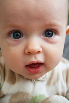 A close-up of a baby making a cute face displaying curiosity or earnestness.