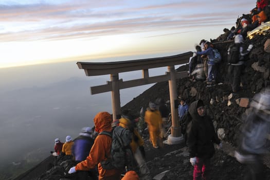 Mt.Fuji peak, Yamanashi, Japan - July 13, 2008: Hikers gathering sunrise on the Mt.Fuji summit. Traditionally Japanese hikers climb mt.Fuji by night to watch sunrise from the summit.