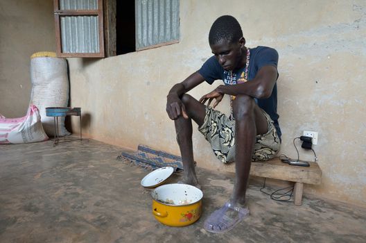KARTIAK, SENEGAL - SEPT 18: An unidentified African teenager prays before eating on September 18, 2012 in Kartiak, Senegal. The region of Casamance, south of Senegal, is a very poor area according to International statistics