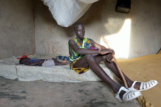 KARTIAK, SENEGAL - SEPT 18: An unidentified African teenager sits in his room on September 18, 2012 in Kartiak, Senegal. The region of Casamance, south of Senegal, is a very poor area according to International statistics