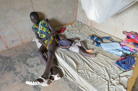 KARTIAK, SENEGAL - SEPT 18: An unidentified African teenager sits in his room on September 18, 2012 in Kartiak, Senegal. The region of Casamance, south of Senegal, is a very poor area according to International statistics