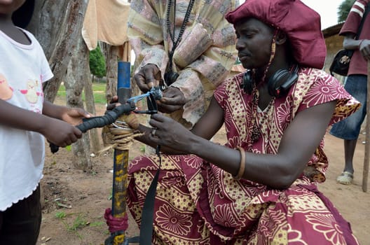 KARTIAK, SENEGAL - SEPT 18: An unidentified African man prepares a gun for the Boukoutt of Initiation ceremony on September 18, 2012 in Kartiak, Senegal. The ceremony occurs every 30 years and celebrates boys becoming men.