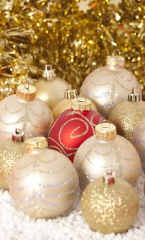 Red and gold Christmas baubles on golden background