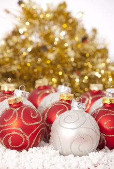 Red and gold Christmas baubles on golden background