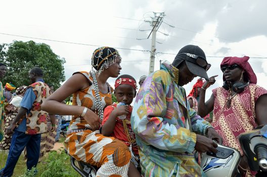 Kartiak,Senegal-September 18,2012 :family in motorbike,go to the ritual of Boukoutt of Initiation ceremony on Sept 18,2012 in Kartiak,Senegal.The ceremony occurs every 30 years and celebrates boys becoming men