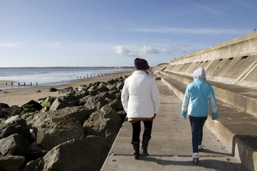 mother and daughter strolling along the beach promenade in Youghal county Cork Ireland
