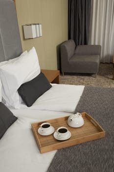 Tray with coffee on a bed in a hotel room