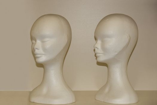 two female pollystyrene female modeling heads on a shelf