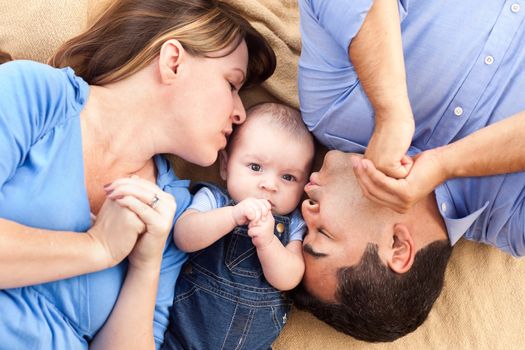 Mixed Race Family with Baby Playing Face Up on the Blanket