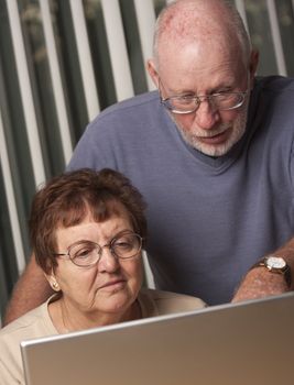 Smiling Senior Adult Couple Having Fun on the Computer Laptop Together.