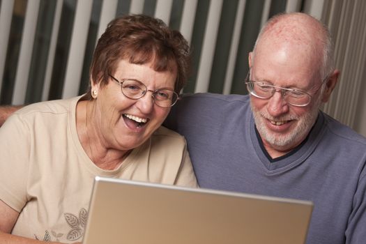 Smiling Senior Adult Couple Having Fun on the Computer Laptop Together.