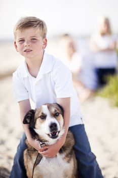 Handsome Young Boy Playing with His Dog at the Beach.
