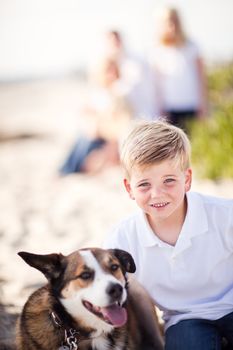 Handsome Young Boy Playing with His Dog at the Beach.
