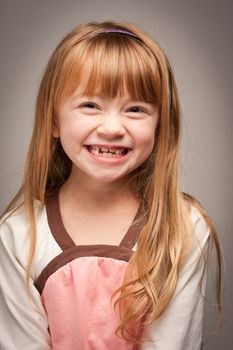 Fun Portrait of an Adorable Red Haired Girl on a Grey Background.