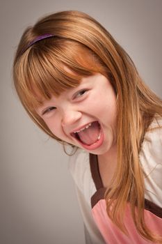 Fun Portrait of an Adorable Red Haired Girl on a Grey Background.