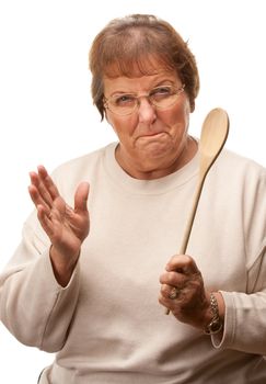 Upset Senior Woman with The Wooden Spoon Isolated on a White Background.