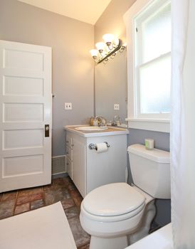 GREY and white small bathroom with open door.