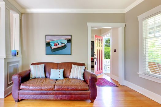 Leather sofa and living room with open door with grey walls.