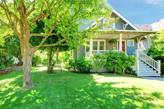 Grey old American house with summer  green landscape.