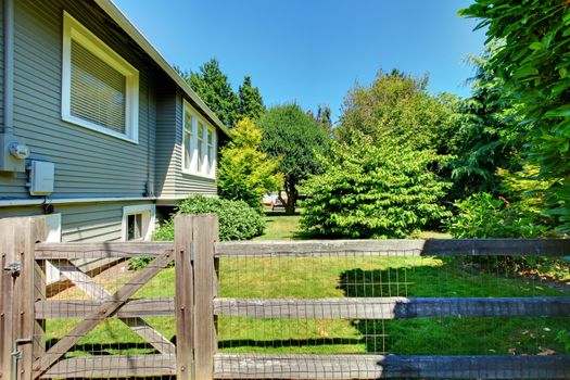 House and shed in the back yard with old wooden fence.