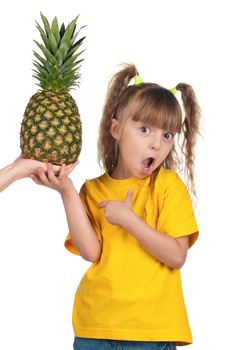 Portrait of surprised little girl with pineapple over white background