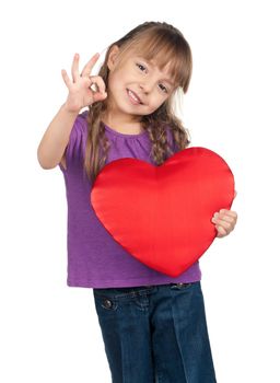 Portrait of little girl holding red heart and gesturing OK over white background