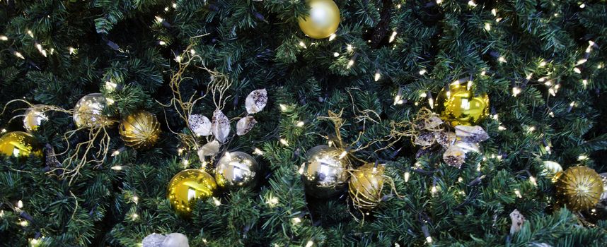 Glittering silver and white Christmas tree decorations by a warm fire