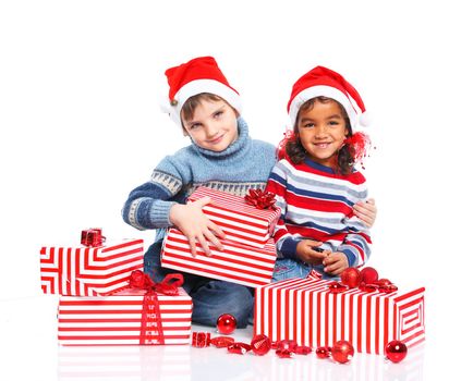 Smiling little mullato girl and her brother in Santa's hat with gift box, isolated on white