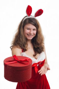 young christmas woman in red santa claus dress is giving a christmas present 