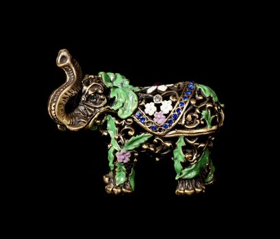 Metal elephant with crystals on the black background (souvenir)