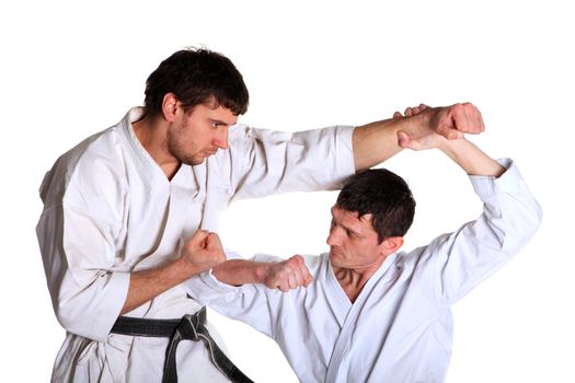 Karate. Men in a kimono with a white background. Battle sports capture
