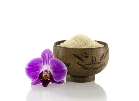 wooden cup of rice with orchid flower