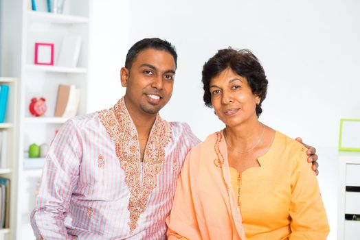 Mature 50s Indian woman and her 30s son sitting at home