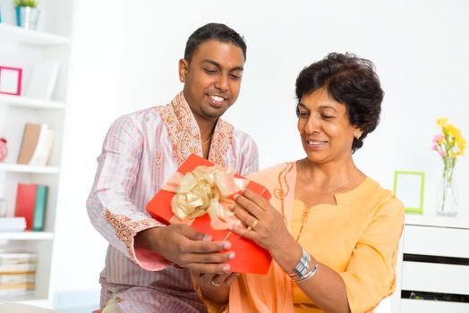 Mature Indian woman receiving a gift from her son