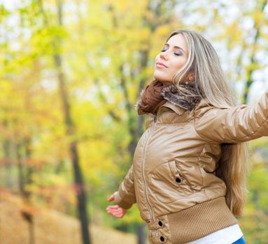 Young woman opening her arms and breathing in a park