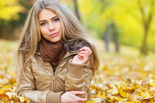 Closeup portrait of a young woman lying in a park