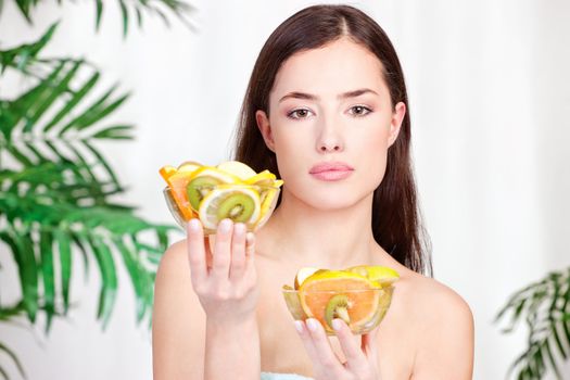 brunette woman holding bowls full of fruit