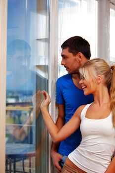 bright picture of happy couple at the window (focus on man)