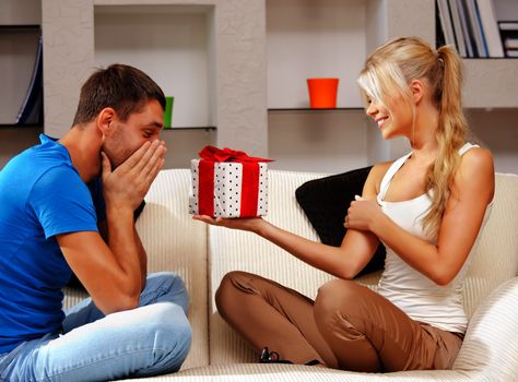 bright picture of happy romantic couple with gift (focus on man)