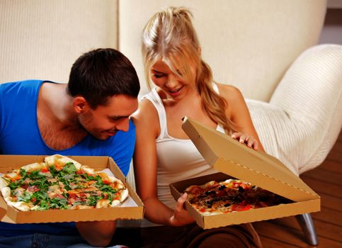 picture of happy romantic couple eating pizza at home (focus on man)